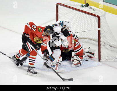 Chicago Blackhawks defenseman Johnny Oduya (L) und San Jose Sharks center Joe Pavelski Crash in goalie Strahl-Schmirgel wie er Uhren Haie center Patrick Marleau das Ziel in das Netz während der ersten Periode in der vereinigten Mitte in Chicago am 22. Februar 2013. UPI/Brian Kersey Stockfoto
