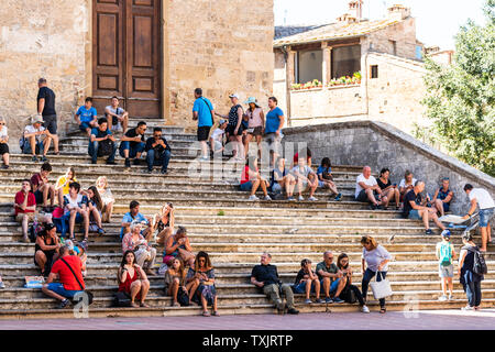 San Gimignano, Italien - 27 August, 2018: die Menschen sitzen auf der Treppe Treppen in kleinen mittelalterlichen Stadt Dorf in der Toskana im Sommer Tag Stockfoto