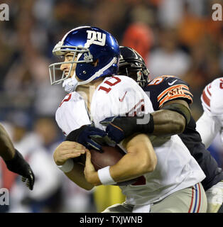 Chicago Bears außerhalb linebacker Lance Briggs (R) Säcke New York Giants Quarterback Eli Manning für eine 7-Yard-Verlust im dritten Quartal mit dem Soldier Field in Chicago am 10. Oktober 2013. Die Bären die Riesen besiegte 27-21. UPI/Brian Kersey Stockfoto