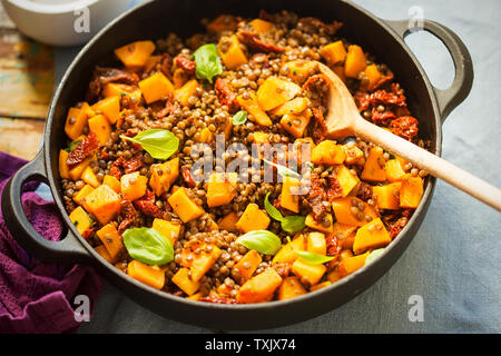 Kürbis mit Linsen, sonnengetrocknete Tomaten und Basilikum Stockfoto