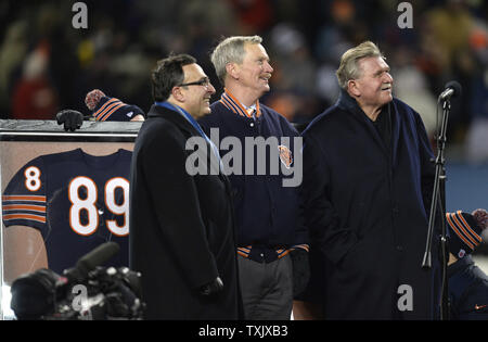 Ehemalige Chicago Bears festes Ende, Head Coach und Pro Football Hall of Famer Mike Ditka (R) steht auf einer Bühne am Mittelfeld mit Chicago Bears Vorsitzender George McCaskey (C) und Präsident und CEO Ted Phillips während einer Halbzeit Zeremonie seine Nummer 89 während die Chicago Bears Dallas Cowboys Spiel bei dem Soldier Field in Chicago in den Ruhestand am 9. Dezember 2013. Ditka gespielt von den Bären von 1961-1966 und trainierte die Mannschaft von 1982-1992, gewinnen Super Bowl XX 1986. UPI/Brian Kersey Stockfoto