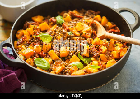 Kürbis mit Linsen, sonnengetrocknete Tomaten und Basilikum Stockfoto