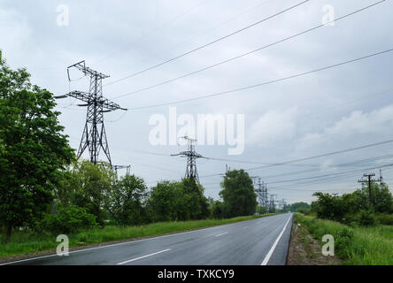 Autobahnen vorbei unter Stromleitungen hoher Spannung. Stockfoto