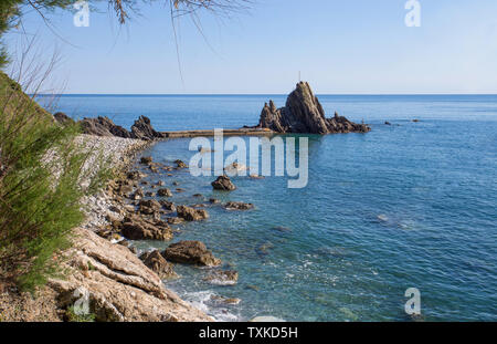 Blick auf den Felsen mit dem Kreuz in der Ortschaft Riva Trigoso, ligurische Riviera, Provinz Genua, Italien Stockfoto