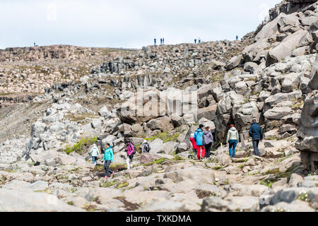 Dettifoss, Island - 16. Juni 2018: Isländische Wasserfall mit felsigen Findlingen Landschaft Trail und viele Menschen zu Fuß wandern zu übersehen Stockfoto