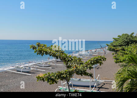 Schwarzen vulkanischen Sand Strand in der Nähe von Agung Vulkan. Tropisches Paradies mit Palmen und majestätischen Vulkan im Hintergrund. Blick von oben. Stockfoto