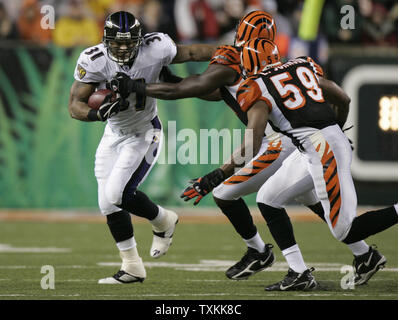 Baltimore Ravens zurück läuft Jamal Lewis (31) steif arme Cincinnati Bengals defensive end Robert Geathers (91) vor dem linebacker Landon Johnson (59), ihn an Paul Brown Stadium in Cincinnati, 30. November 2006, in Angriff nimmt. (UPI Foto/Markierung Cowan) Stockfoto