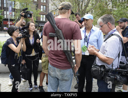 Jesse Gonzales, Lakewood, Ohio Gespräche zu den Reportern mit einem Sturmgewehr umschlungen auf seinem Rücken auf dem öffentlichen Platz an der Republican National Convention in Quicken Loans Arena in Cleveland, Ohio am 18. Juli 2016. Donald Trump wird formal akzeptieren Nominierung der Republikanischen Partei als Präsident in der Nacht zum Donnerstag 21. Juli. Foto von Mike Theiler/UPI Stockfoto