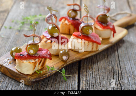 Spanische pinchos: Spieß snacks gegrilltes Brot mit gerösteten und eingelegte Paprika, gefüllte Oliven und Sardellen Filets Stockfoto