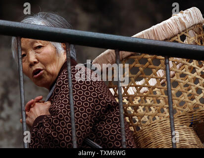 Eine ältere chinesische Frau Köpfe auf dem Markt in bergigen Jiayang, einer kleinen Stadt in der Provinz Sichuan, am 10. April 2016. China, das bevölkerungsreichste Land der Welt, hat einen relativ kleinen Jugend demographischen, die teilweise das Ergebnis von Chinas Ein-Kind-Politik. Foto von Stephen Rasierer/UPI Stockfoto