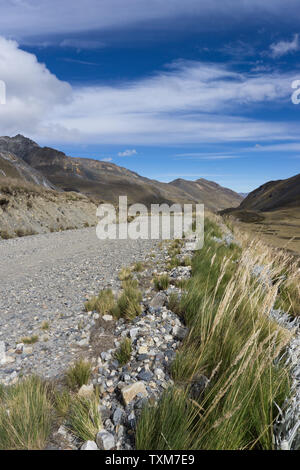 Schotterstraße durch leere Hochalpine wiesen in den Anden von Peru schneiden in der Mitte von Nirgendwo Stockfoto