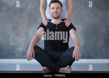 Sicher entspannter junger Mann mit gekreuzten Beinen, Yoga Stockfoto