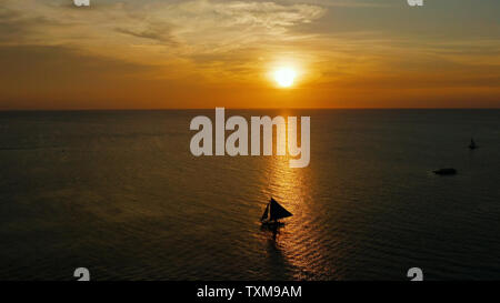 Sonnenuntergang über dem Meer Fläche mit Segelyachten, Luftaufnahme Boracay, Philippinen. Spiegelt sich die Sonne auf einer Wasseroberfläche. Sonnenuntergang über dem Meer. Marine, Sommer und Reisen Urlaub Begriff Stockfoto