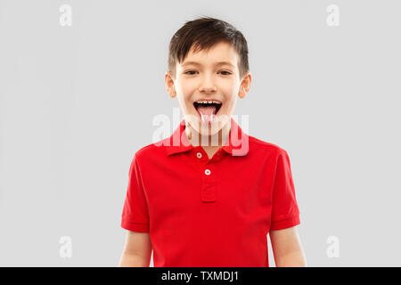 Junge in rot Polo T-Shirt seine Zunge angezeigt Stockfoto