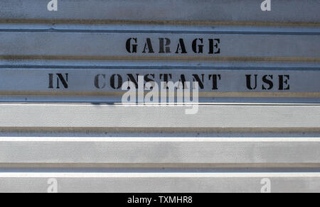 Juni 2019, Swansea, Wales. Garage in ständigem Gebrauch Nachricht auf einem grauen Metall Garagentor Stockfoto