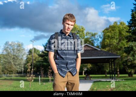 Angry student stehend auf einem Gehweg, der zu einem kleinen Pavillon führt. Stockfoto