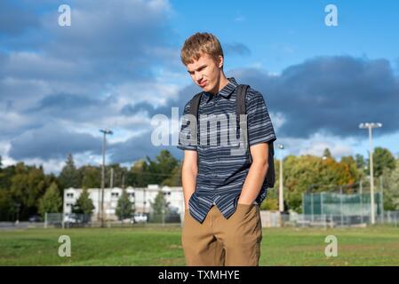 Angry student stehend auf einem Gehweg, der zu einem kleinen Pavillon führt. Stockfoto