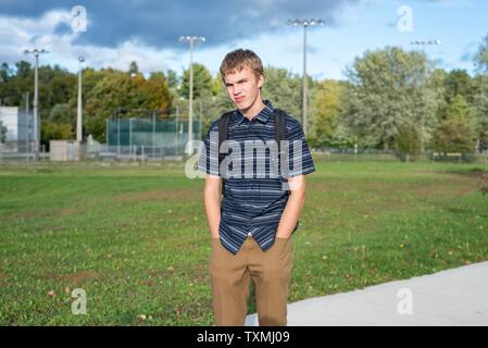 Angry student stehend auf einem Gehweg, der zu einem kleinen Pavillon führt. Stockfoto