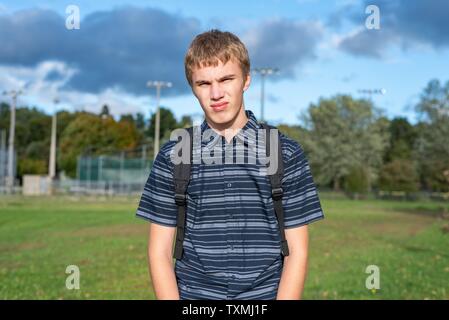 Angry student stehend auf einem Gehweg, der zu einem kleinen Pavillon führt. Stockfoto