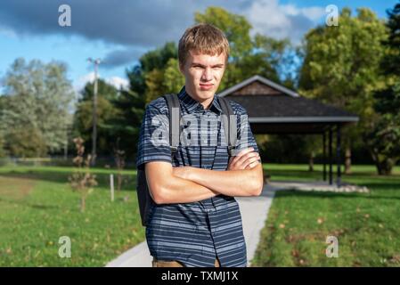 Angry student stehend auf einem Gehweg, der zu einem kleinen Pavillon führt. Stockfoto