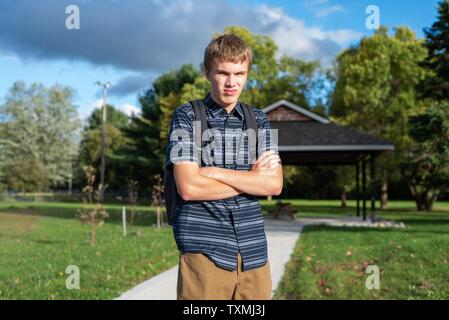 Angry student stehend auf einem Gehweg, der zu einem kleinen Pavillon führt. Stockfoto