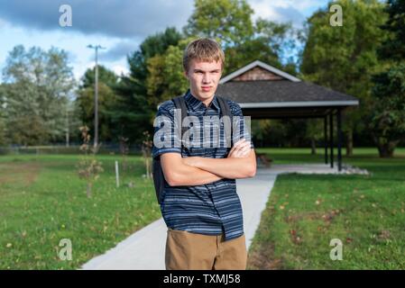 Angry student stehend auf einem Gehweg, der zu einem kleinen Pavillon führt. Stockfoto