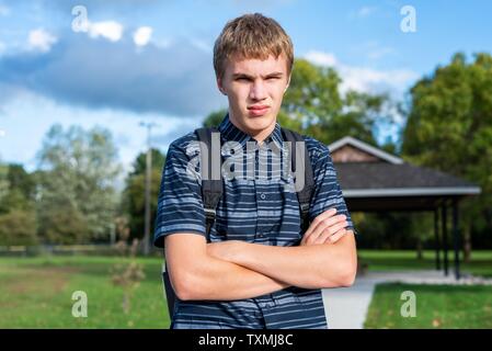 Angry student stehend auf einem Gehweg, der zu einem kleinen Pavillon führt. Stockfoto