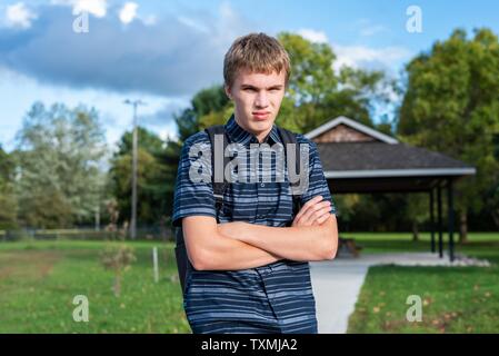 Angry student stehend auf einem Gehweg, der zu einem kleinen Pavillon führt. Stockfoto