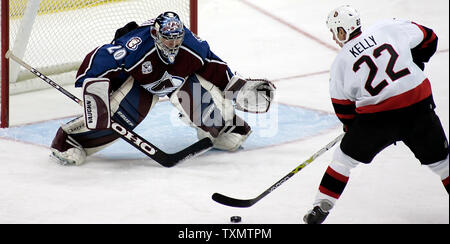 Colorado Avalanche goalie Witali Kolesnik (L) macht eine Speichern gegen die Ottawa Senators rechten Flügel Chris Kelly auf einem Ausbrechen in der zweiten Periode bei der Pepsi Center in Denver, Colorado, 12. Dezember 2005. (UPI Foto/Gary Caskey) Stockfoto