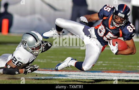 Denver Broncos wide receiver Ashley Lelie (R) wird von der Oakland Raiders cornerback Stanford Routt ausgelöst, nachdem ein Pass Empfang bei Invesco Field in Denver, Colorado, 24. Dezember 2005. (UPI Foto/Gary Caskey) Stockfoto