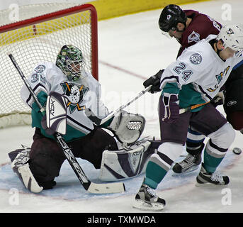 Der Anaheim Mighty Ducks goalie Jean-Sebastien Giguere (L) macht eine gegen die Colorado Avalanche linken Flügel Andrew Brunette (Zweiter von rechts) in der ersten Periode bei der Pepsi Center in Denver, 28. März 2006 speichern. Mighty Ducks defenseman Rusian Salei (R) hilft auf dem Spiel verteidigen. (UPI Foto/Gary C. Caskey) Stockfoto