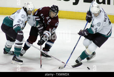 Colorado Avalanche center Joe Sakic (C) dreht den Puck hinter der Anaheim Mighty Ducks Defenseman Scott Miedermayer (L) und Rob Niedermayer(R) im Pepsi Center in Denver, 28. März 2006. Colorado übernahm den ersten Platz in der Northwest Division mit einem 4-3 über Anaheim gewinnen. (UPI Foto/Gary C. Caskey) Stockfoto