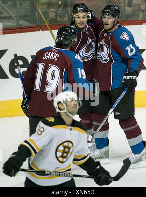 Colorado Avalanche rechten Flügel Milan Hejduk (23) feiert sein Ziel mit Mannschaftskameraden Ryan Smyth und Joe Sakic (19) Boston Bruins center Stephane Yelle Vergangenheit Skates in der ersten Periode bei der Pepsi Center in Denver am 9. Oktober 2008. Colorado Hosts die Bruins im Jahreszeitöffner für beide Mannschaften. (UPI Foto/Gary C. Caskey) Stockfoto