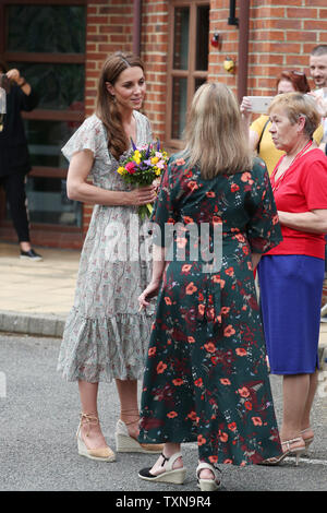 Die Herzogin von Cambridge spricht mit unbekannter Frauen wie sie Warren's Park Kinder Center, Kingston upon Thames, nach der Teilnahme an einem Royal Photographic Society Workshop mit Aktion für Kinder, die mit der Fotografie zu helfen jungen Menschen, Vertrauen und Self-expression entwickeln lässt. Stockfoto