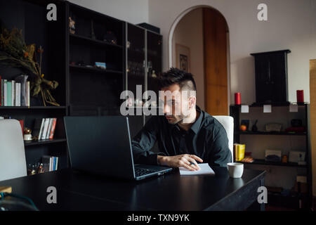 Mann mit Laptop im home-office Stockfoto