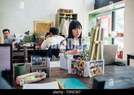 Junge geschäftsfrau am Laptop im Cafe suchen Stockfoto