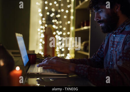 Junger Mann mit Laptop zu Hause Bärtigen Stockfoto