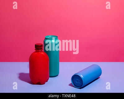 Noch immer leben in Türkis und blau Getränkedosen mit roter Flasche und rosa Hintergrund Stockfoto
