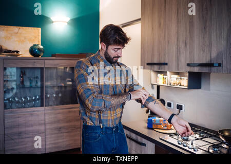 Mitte der erwachsenen Mann in der Küche bis Rolling shirt Hülse Stockfoto