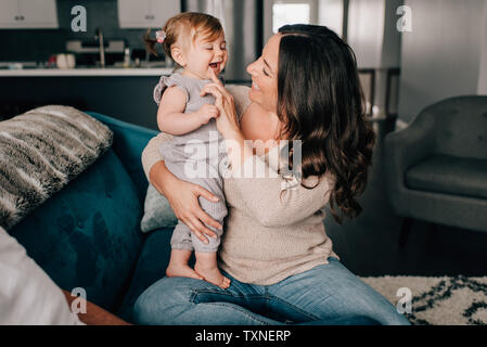 Mutter mit Tochter auf Sofa spielen Stockfoto