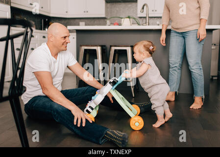 Mutter Vater spielen mit Baby Tochter in der Küche Stockfoto