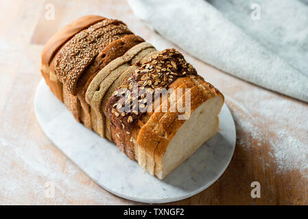 In Scheiben geschnitten Brot aus der Vielzahl von Weiß- und Vollkornmehl Slices auf Schneidebrett, hohe Betrachtungswinkel Stockfoto