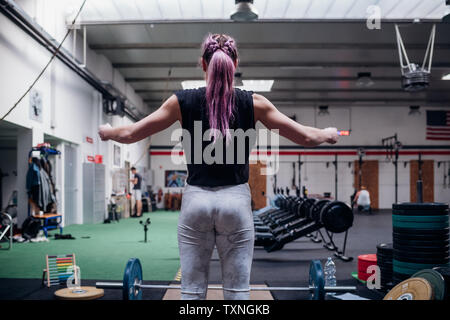 Junge Frau, die Hantel heben Sie im Fitness-Studio wird vorbereitet Stockfoto