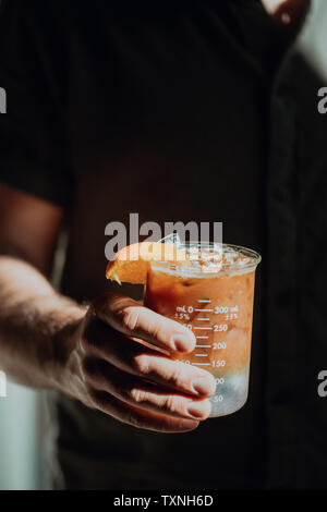 Barista Holding frischen Eistee Fruchtsaft in Messbecher, 7/8-Nahaufnahme von Hand Stockfoto