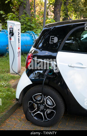 Ein Smart Forfour an eine Ladestation der Mobilstation auf dem Charles-de-Gaulle im Stadtteil Deutz, Köln, Deutschland. Mit einer direkten Conne Stockfoto