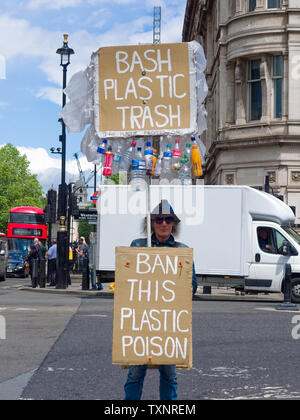 Person, die auf dem Parliament Square, London, England, Großbritannien, mit Plakaten gegen Einweg-Plastik steht. Stockfoto
