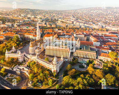 Luftaufnahme der Fischerhochburg und Matthias Kirche von oben in Budapest bei Sonnenaufgang im Herbst mit dramatischen Himmel (Budapest, Ungarn, Europa) Stockfoto