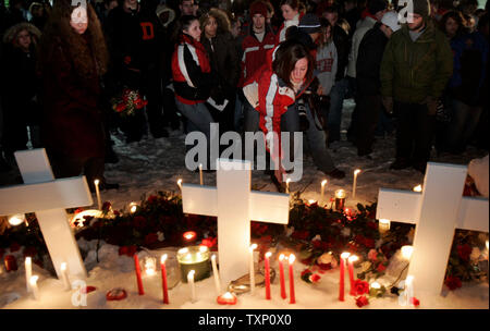 Die Studierenden legen Blumen an einem provisorischen Denkmal nach eine Mahnwache für die Opfer auf dem Campus der Northern Illinois Universität in DeKalb, Illinois, am 15. Februar 2008. Stephen Kazmierczak fünf Menschen getötet und 16 verwundet in einem Hörsaal auf dem Campus vor seinem eigenen Leben, die am 14. Februar. (UPI Foto/Markierung Cowan) Stockfoto