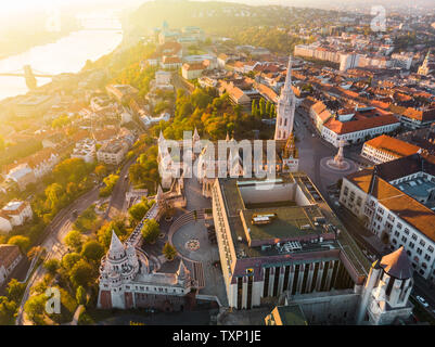 Luftaufnahme der Fischerhochburg und Matthias Kirche von oben in Budapest bei Sonnenaufgang im Herbst mit dramatischen Himmel (Budapest, Ungarn, Europa) Stockfoto