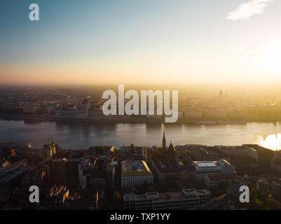 Luftbild des ungarischen Parlaments in Budapest von oben mit Donau und neben St-Stephans-Basilika bei Sonnenaufgang (Budapest) Stockfoto